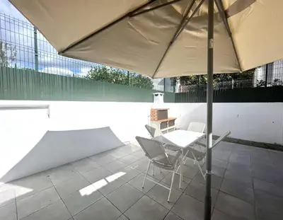 a patio with a table and chairs and an umbrella at Sun II - City center by HD PROPERTIES in Vilamoura