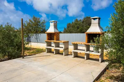 two benches sitting on a sidewalk in front of a fence at By the sea, Algarve in Galé