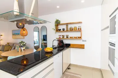 a kitchen with white cabinets and a counter top at By the sea, Algarve in Galé