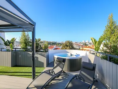 a patio with a table and chairs on a balcony at Luxury Penthouse Apartment Private Jacuzzi, Albufeira in Albufeira