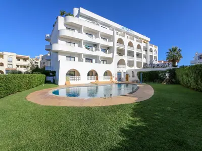 a large white building with a swimming pool in front of it at Luxury Penthouse Apartment Private Jacuzzi, Albufeira in Albufeira