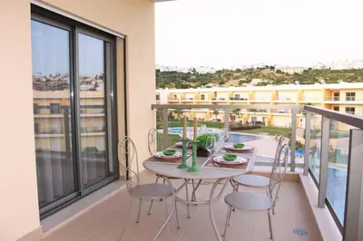 a table and chairs on a balcony with a view of a building at Apartment Amelo in Albufeira