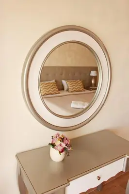 a mirror on a wall above a table with flowers at Apartment Amelo in Albufeira