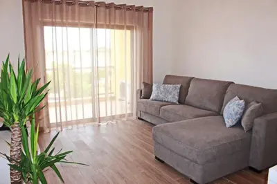 a living room with a couch and a large window at Apartment Amelo in Albufeira