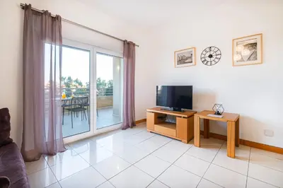 a living room with a tv and a large window at Apartment Oura - Views of sea, Albufeira bay & Old Town in Albufeira