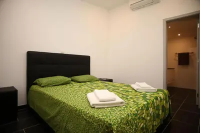 a bedroom with a green bed with two towels on it at Apartment Aiko - Downtown Albufeira in Albufeira