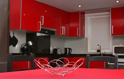 a red kitchen with a red table with a bowl on it at Apartment Aiko - Downtown Albufeira in Albufeira