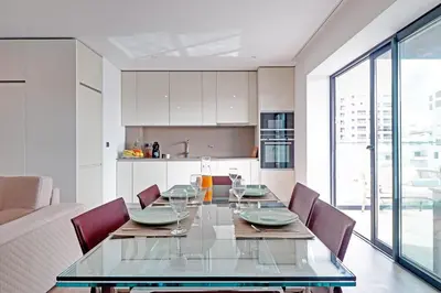 a dining room with a glass table and chairs at Sky Beach Apartment in Quarteira