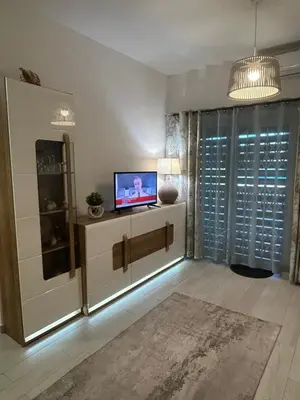 a living room with a television on a cabinet at Casa Garcia in Quarteira