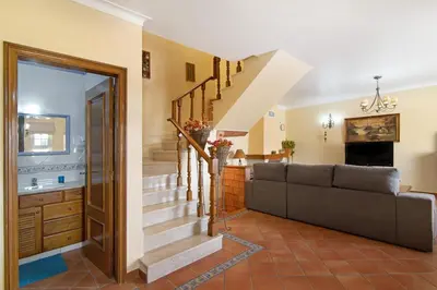 a living room with a couch and stairs at Villa Guisado in Albufeira