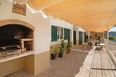 an outdoor patio with a pizza oven in a building at Villa Guisado in Albufeira