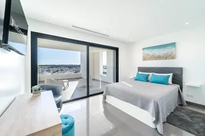 a bedroom with a bed and a balcony at Villa das Amendoeiras by HelloVacations in Albufeira