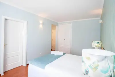 a white room with a bed and a chair at Apartment Claro Azul in Albufeira