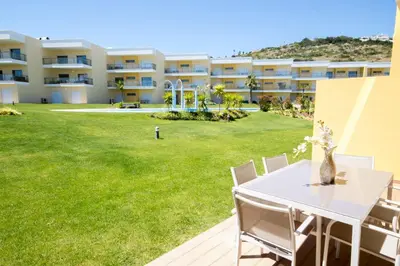 a white table and chairs in front of a building at Marina Jardim - Great complex for families in Albufeira