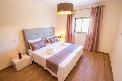 a bedroom with a large bed and a window at Marina Jardim - Great complex for families in Albufeira