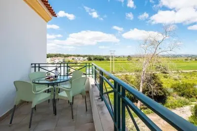 a patio with a table and chairs on a balcony at Apartment Alfarmar - pool, beach only a few minutes away in Albufeira