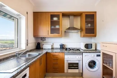 a kitchen with a sink and a washing machine at Apartment Alfarmar - pool, beach only a few minutes away in Albufeira