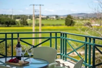 a table with a bottle of wine and glasses on a balcony at Apartment Alfarmar - pool, beach only a few minutes away in Albufeira