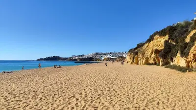 a beach with people sitting on the sand at Albufeira, Modern Sea View Home 33 in Albufeira