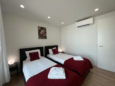 a bedroom with two beds with red and white sheets at Faro Design 5 by Homing in Faro