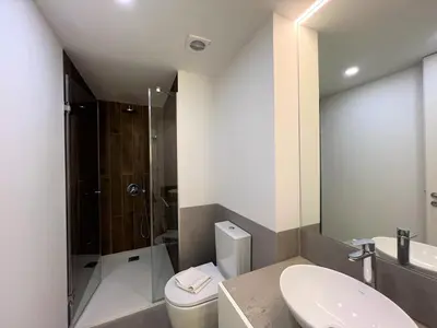 a bathroom with a toilet and a sink and a shower at Faro Design 5 by Homing in Faro