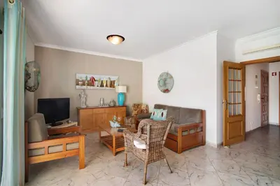 a living room with a couch and a television at Columbus Beach Apartment in Quarteira