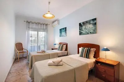 a bedroom with two beds and a window at Columbus Beach Apartment in Quarteira