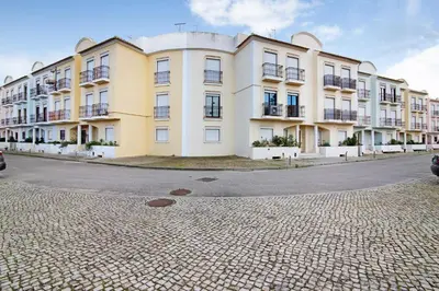 a large white building on the side of a street at Columbus Beach Apartment in Quarteira