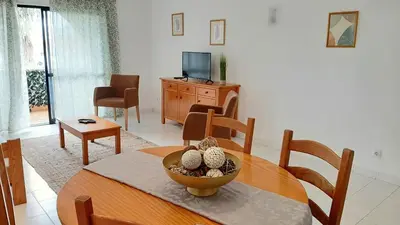 a living room with a table and a television at Apartamento AnaMar by Sunnyway in Albufeira
