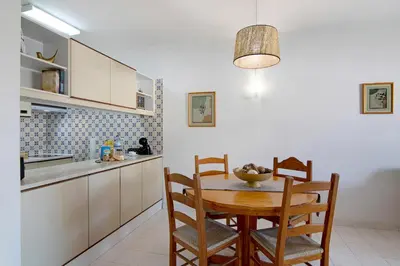 a kitchen with a table and chairs in a room at Apartamento AnaMar by Sunnyway in Albufeira