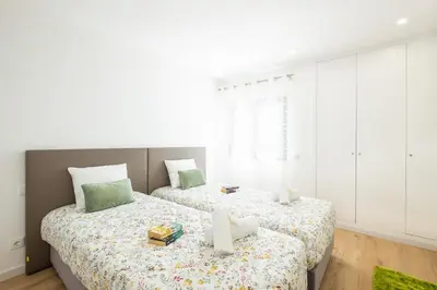 two beds in a bedroom with white walls at Apartment Brisbane by Algarve Vacation in Albufeira
