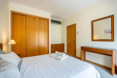 a bedroom with a white bed and a mirror at SeaViewSunset - Encosta da Orada in Albufeira
