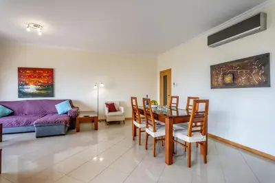 a living room with a table and a couch at SeaViewSunset - Encosta da Orada in Albufeira
