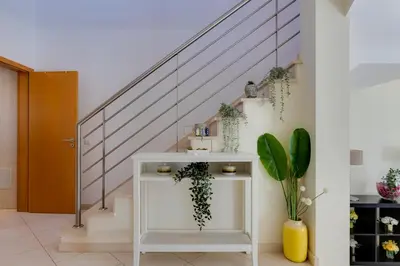 a staircase with a white table with plants at BALAIA RESIDENCE - Fantástica moradia para 6 com piscina e BBQ in Olhos de Água