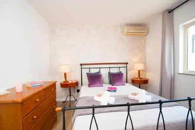 a bedroom with a bed with purple pillows and a dresser at Villa Hollywood by Algarve Vacation in Albufeira