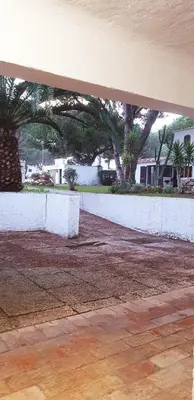 a parking lot with trees and a white wall at Estúdio na Falésia in Albufeira