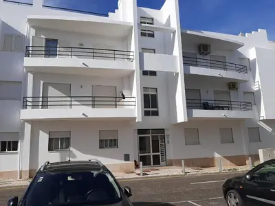 a white building with cars parked in front of it at Apartamento Kaya by Sunnyway in Albufeira