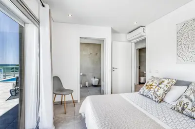 a bedroom with a bed and a view of a bathroom at Ocean Chic by the Beach in Albufeira