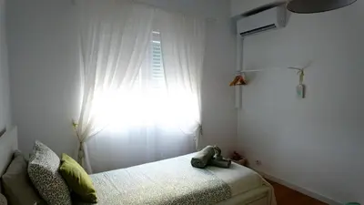 a bedroom with a window with a white curtain at BENAMAR HOUSE in Quarteira