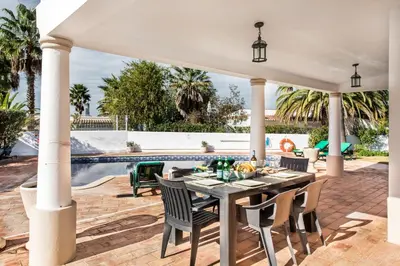 an outdoor patio with a table and chairs and a pool at Celina by Algarve Villa Holidays in Guia
