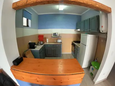 a small kitchen with green cabinets and a wooden table at Algarve, modern T1 apartment with balcony, Quarteira in Quarteira