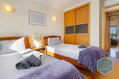 a hotel room with two beds and a window at Quinta do Pinheiro Residence AN - Dream Lodging in Albufeira