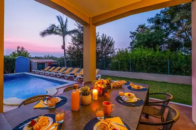 a table with food on it next to a swimming pool at Villa Hawaii by Algarve Vacation in Albufeira