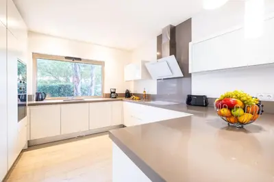 a white kitchen with a vase of fruit on a counter at Villa Laura by Algarve Vacation in Albufeira