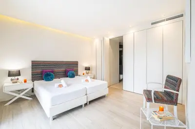 a white bedroom with a white couch and a chair at Villa Laura by Algarve Vacation in Albufeira