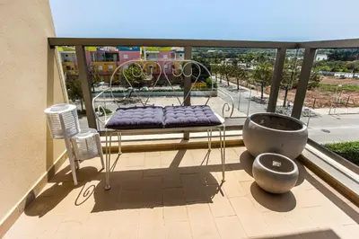 a balcony with a bench and a table and chairs at Apartment Aria - Great area for children in Albufeira