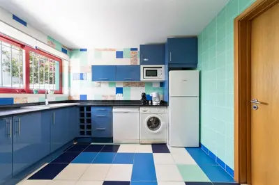 a blue and white kitchen with a washing machine at Villa Marina in Albufeira