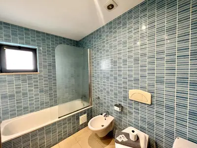 a blue tiled bathroom with a toilet and a sink at Albufeira Modern 3 With Pool by Homing in Albufeira