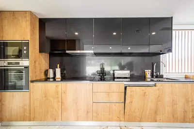 a kitchen with wooden cabinets and stainless steel appliances at BeGuest Albufeira Luxus Villa in Albufeira