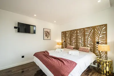 a bedroom with a bed with a tv on the wall at BeGuest Albufeira Luxus Villa in Albufeira